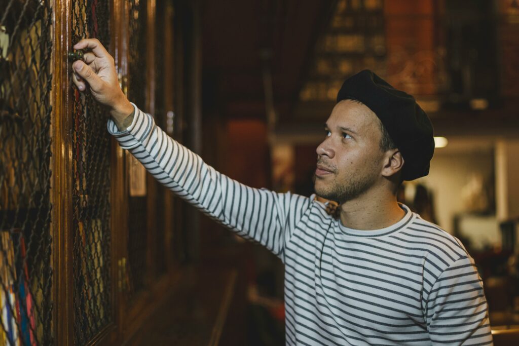 A man in a striped shirt examines a book in a historical library in Buenos Aires, Argentina.